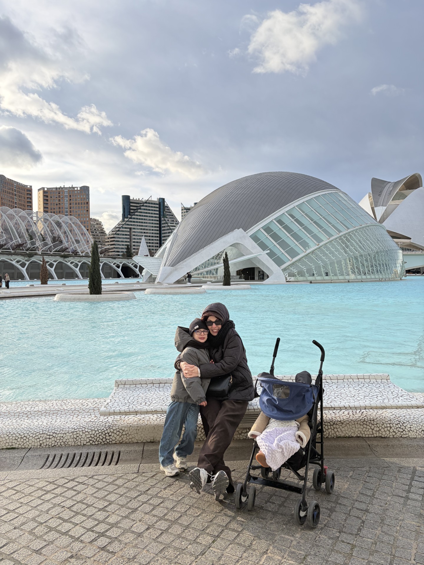 mamma e figli e sullo sfondo ila città delle arti e della scienza
